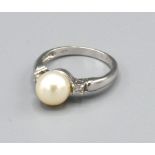 A 18ct White Gold Pearl and Diamond Ring set with a large central pearl surrounded by two diamonds