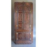 A 19th Century Oak Standing Corner Cabinet with two arched doors enclosing shelves and small drawers