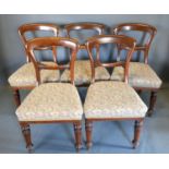 A Set of Five Victorian Mahogany Dining Chairs each with a shaped rail back above a stuffed over-