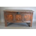 An 18th Century Oak Coffer, the hinged top above a three panel inlaid front flanked by stiles and