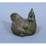 A Patinated Small Bronze Model of a Chicken with Chicks, 4cm long