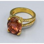 An 18ct Gold Morganite and Diamond Ring with a large oval Morganite claw set and double diamond band