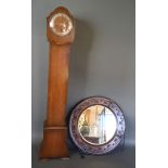 An Early 20th Century Oak Circular Wall Mirror, together with an early 20th century oak longcase