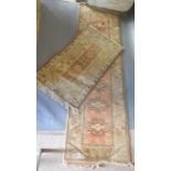 A Turkish Woollen Runner with an all over design upon a pale cream and terracotta ground with