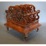 A Victorian Walnut Four Division Canterbury of pierced shaped form with frieze drawer raised upon
