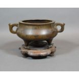 An 18th Century Chinese Patinated Bronze two-handled Sensor with hardwood stand, 13cm diameter