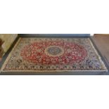 An Isfahan woollen Rug with a central medallion within an allover design upon a red and blue ground