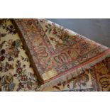 A Ghom Silk Rug decorated with birds amongst foliage upon a cream ground within multiple borders,