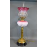 A Victorian Brass and Glass Oil Lamp with brass column and cranberry glass and opaque shade and