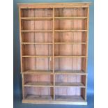 A late 20th Century Pine Bookcase with moulded cornice above open shelves, raised upon a plinth,