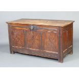 A 18th Century Oak Coffer the hinged top above three carved panel front flanked by styles and with