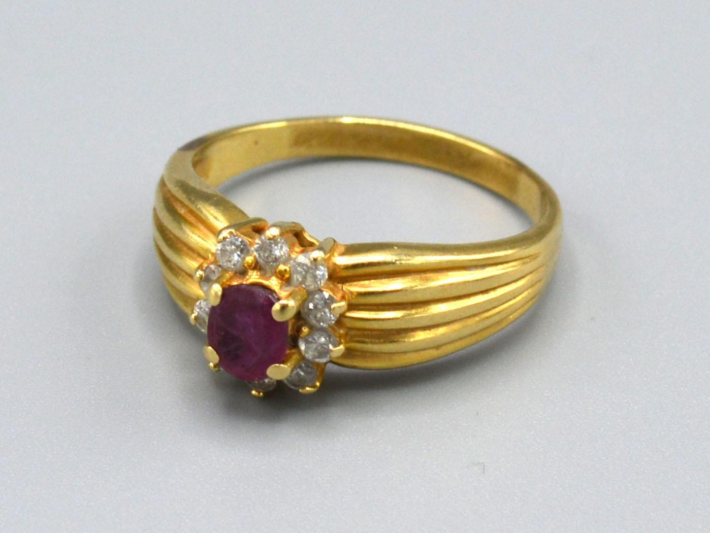 A tested 18ct Yellow Gold Ruby and Diamond Ring set with central ruby surrounded by diamonds