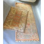 A Turkish Woollen Rug with an all over design on a pale cream and terracotta ground together with