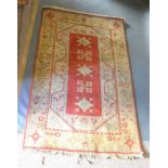 A Turkish Woollen Rug with an all over design upon a red and cream ground with multiple borders