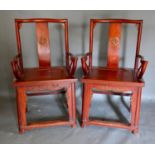 A Pair of Chinese Hardwood Armchairs, each with a shaped carved back above a panel seat raised