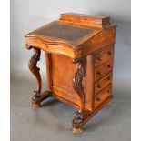 A Victorian Walnut Davenport with a Stationary Compartment above a hinged writing surface with