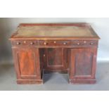 A Victorian Mahogany twin pedestal desk with three drawers above a centre knee hole flanked by