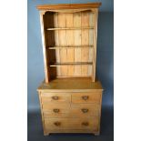 A Pine Dresser with boarded shelf back against two short and two long drawers with brass handles