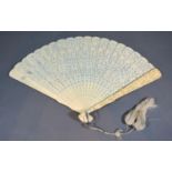 A 19th Century Chinese Carved Ivory Fan with finely pierced sticks and carved guards within a fitted
