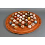 A Turned Wooden Solitaire Board together with a full set of semi precious stone marbles to include