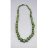A Jade Bead Necklace with graduated beads and yellow metal clasp, 65cm long