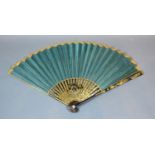 A Regency Period Fan with plain green silk leaf within a gilt border, lacquered sticks and guards,