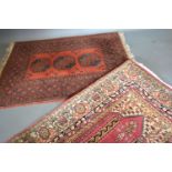 A Bokhara Woollen Rug with three central medallions with a red ground in multiple boarders 145cm x