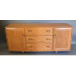 An Ercol Blonde Ash Sideboard with three central drawers flanked by cupboard doors with cup handles,