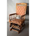 An American Walnut Rocking Chair with a Fleur-de-Lys upholstered back and seat raised upon shaped