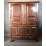 A George III Oak Bacon Cupboard, the moulded cornice above two moulded panel doors enclosing a
