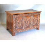 An 18th Century Oak Coffer, the hinged top above a three panel carved front flanked by stiles, 108