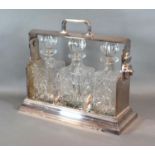 A Silver Plated Tantalus with three cut glass decanters and stoppers, 38 cms wide