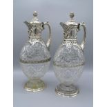 A Pair of Victorian Silver and Cut Glass Claret Jugs each with a pineapple finial and shaped
