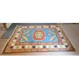 A Kazak Woollen Rug with a central medallion within an all-over design upon a terracotta, blue and