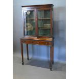 An Edwardian Mahogany Display Cabinet with two glazed doors enclosing shelves, the lower section