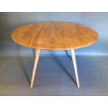 An Ercol Blonde Ash Drop Flap Dining Table of oval form raised upon square tapering splay legs,