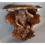 A Carved Oak Corner Wall Bracket of figural form 38 cms tall