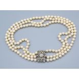 A Triple Row Cultured Pearl Necklace, the 18ct. white gold clasp with a central diamond cluster