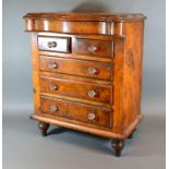 A Victorian Burr Walnut Apprentice Chest with a concealed frieze drawer above two short and three