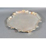 A George V Silver Salver of shaped outline with four shaped feet, London 1911, 22 ozs., 27 cms