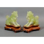 A Pair of Chinese Jade Models in the form of temple dogs, each with a hardwood stand, 13 tall