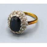 An 18ct. Gold Sapphire and Diamond Cluster Ring with an oval sapphire surrounded by diamonds