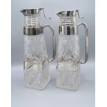 A Pair of Victorian Silver and Cut Glass Claret Jugs each with a double silver band and shaped