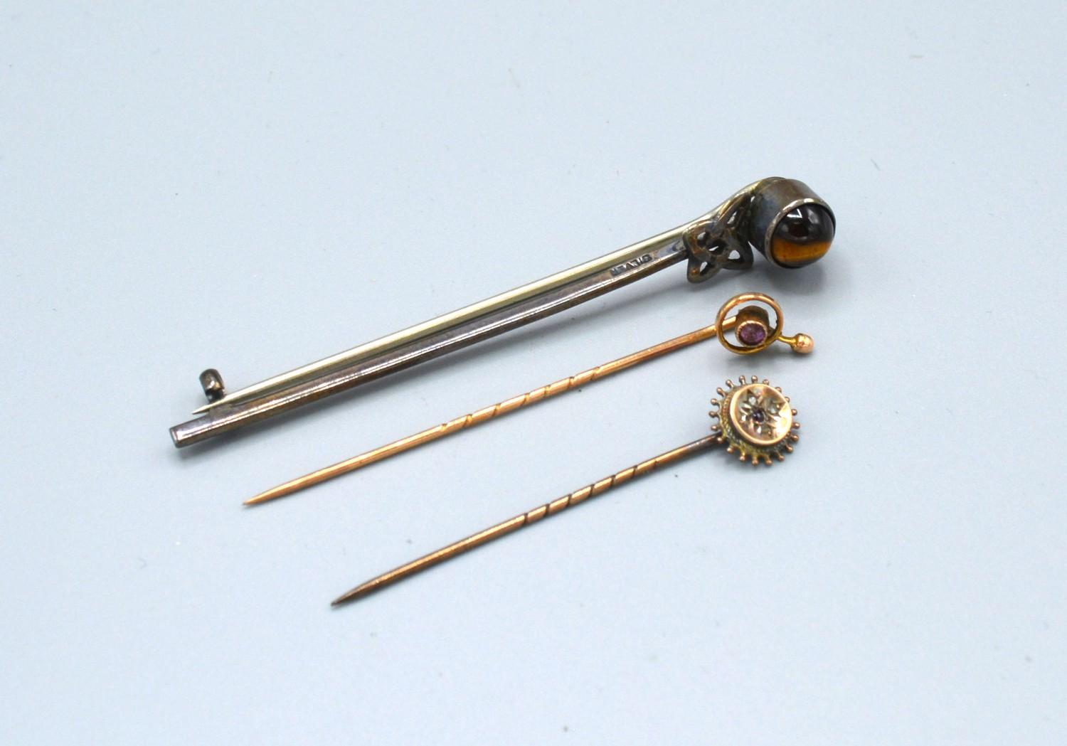 A Yellow Metal Stick Pin set garnet and diamonds together with two other stick pins