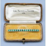 A Yellow Metal Bar Brooch Set With Emeralds And Diamonds, 3.9 grams, 5.5cms long, with box