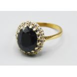 A 9ct Gold Sapphire And Diamond Cluster Ring, the large oval sapphire surrounded by diamonds