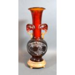 An Early 20th Century Chinese Amber Resin Vase with hardwood stand, 24 cms tall