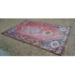 A North West Persian Woollen Carpet with three central medallions with an all over design upon a