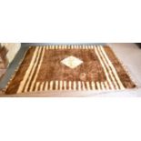 A Woollen camel Rug with a cream and brown design 220 x 153 cms