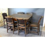 A 20th Century Oak Dining Room Suite comprising a draw leaf table with six chairs and a matching
